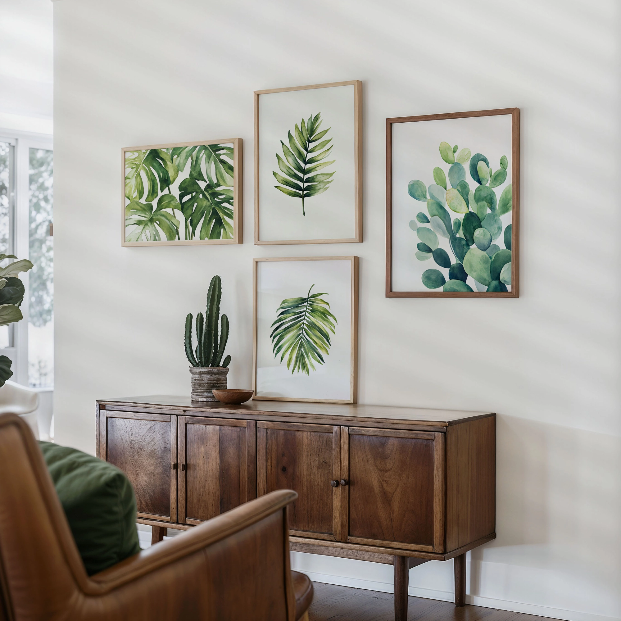 Set of botanical wall art prints featuring green leaves and plants, arranged as a gallery wall above a wooden cabinet in a modern living room.