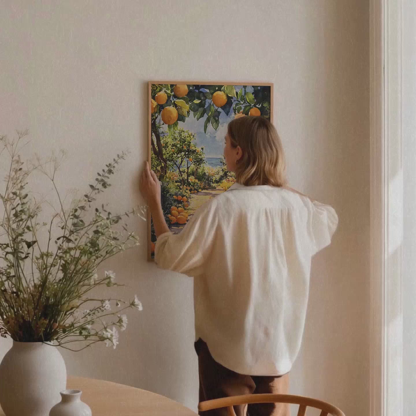 Video laden: Gerahmtes Veróme Toscana Serenity Poster als Mockup Video in einem stilvollen Interior mit mediterrischem Kunstmotiv, warmen Farben und hochwertigem Holzrahmen.