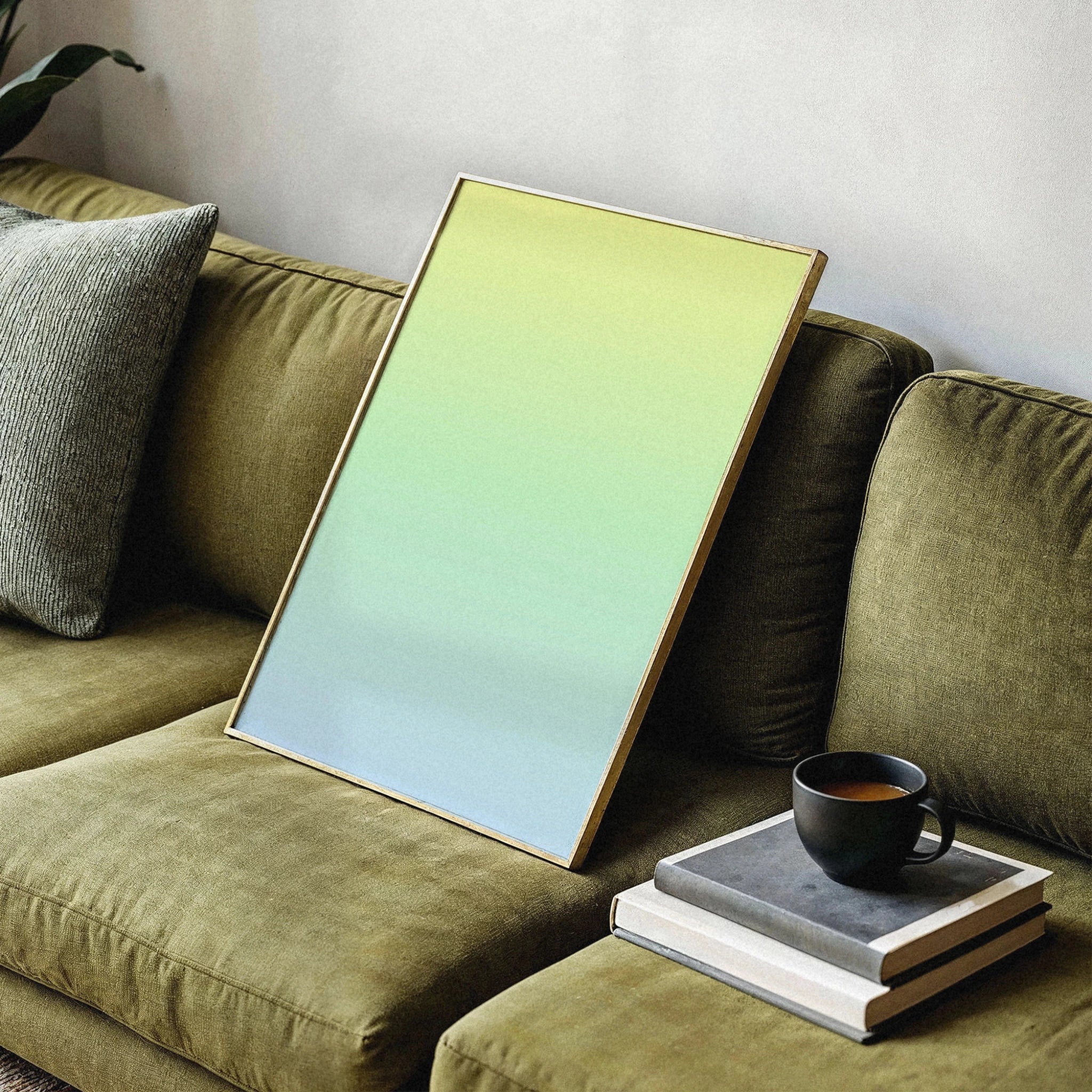 Veróme Color Cascade Poster in Holzrahmen auf olivgrünem Sofa — abstrakter Farbverlauf in Gelb und Hellblau, modernes Wandbild aus der Gallery Series